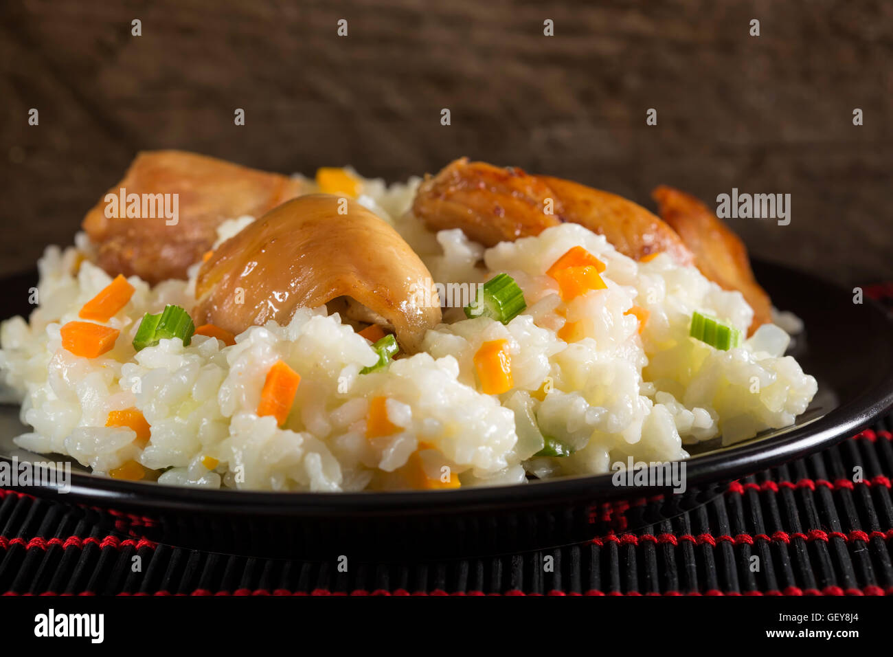 Ein Teller mit Reis mit gebratenem Huhn und Gemüse. Selektiven Fokus. Stockfoto