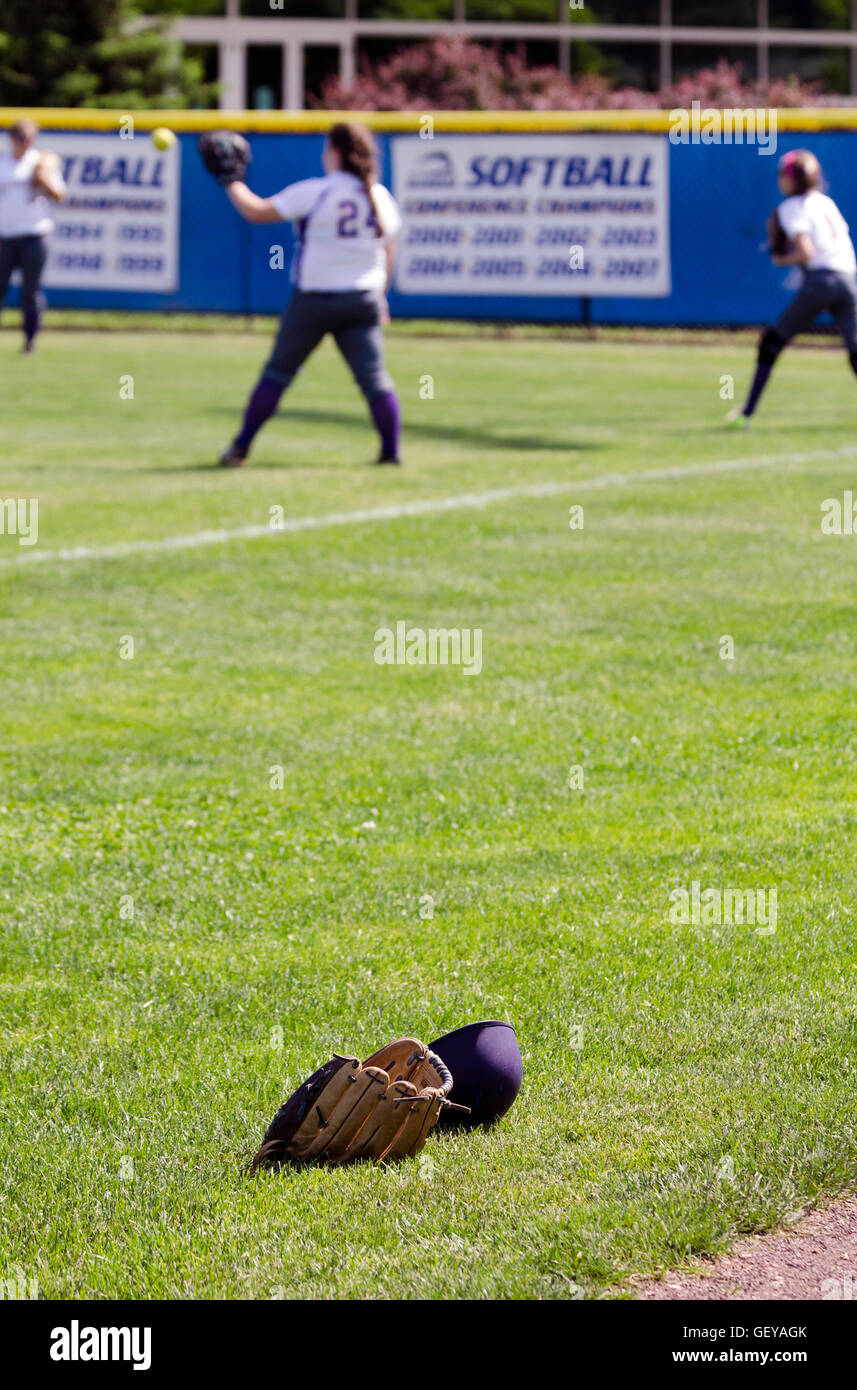 Softball-Ausrüstung mit Spielern im Hintergrund Stockfoto