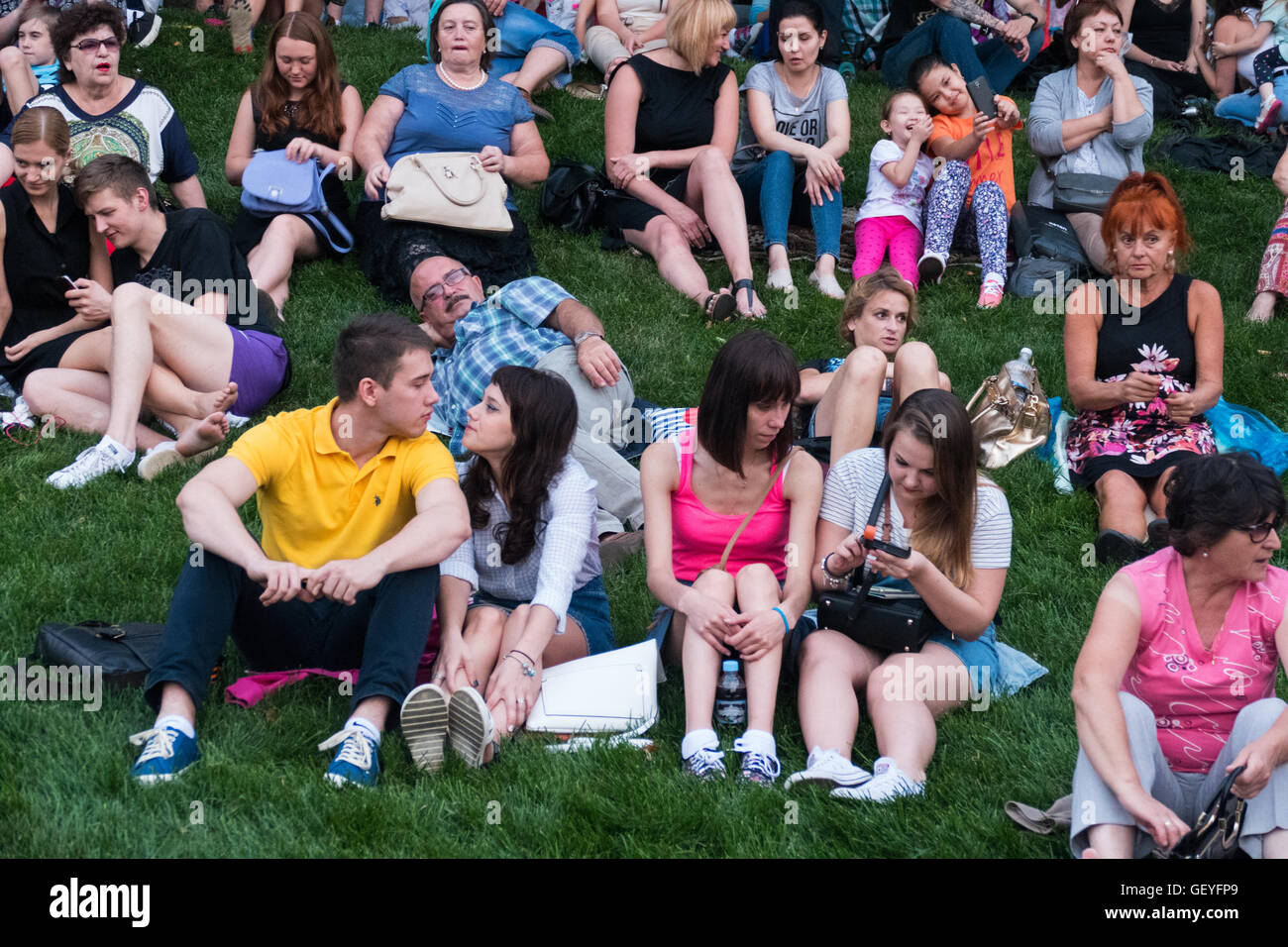 Menschen sitzen auf dem Rasen warten auf das Spektakel Stockfoto