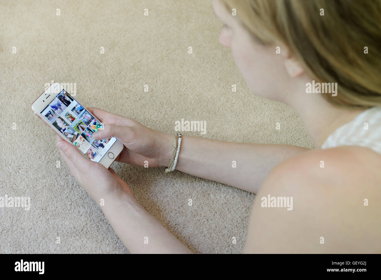 Teenager-Mädchen über Instagram-social-Media-app auf ihr Handy (Iphone) Stockfoto