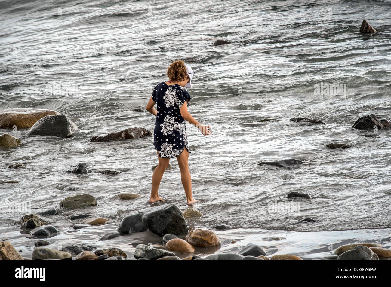 Ein Mädchen geht entlang der Ozeane auf der Suche nach Schätze mit nach Hause mit ihr nehmen, ihre Sommer-Erinnerungen lebendig zu halten mit ihr. Stockfoto