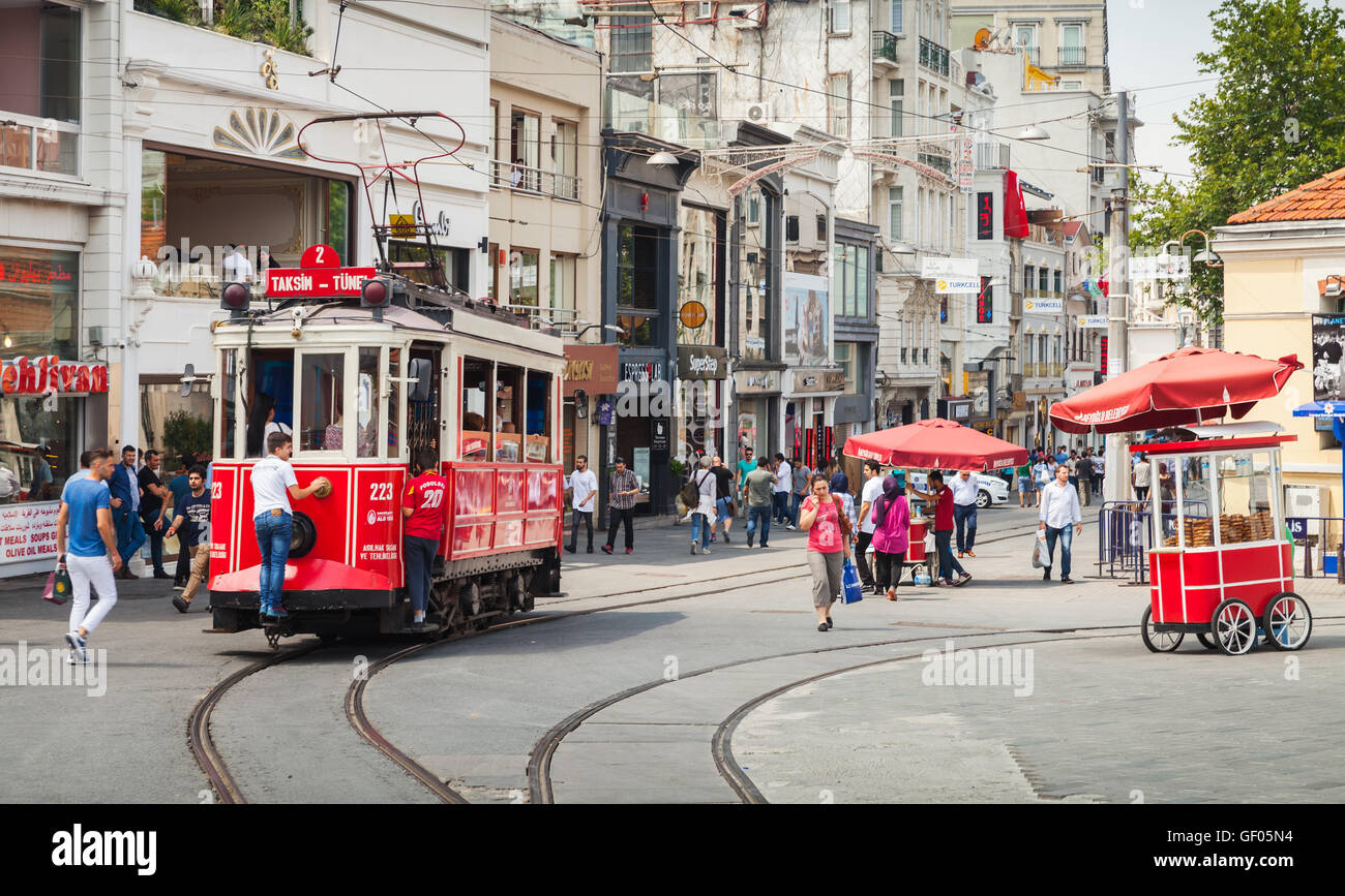 Istanbul, Türkei - 1. Juli 2016: Vintage rote Straßenbahn fährt auf der Istiklal Straße in Istanbul, jungen Fahrt kostenlos auf der Stoßstange Stockfoto