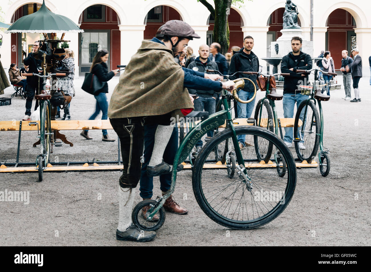 München, Deutschland - 5. Mai 2015: Alte Fahrräder genannt: Penny Farthing,  in einem Park in München mit Menschen mit traditioneller Kleidung  Stockfotografie - Alamy