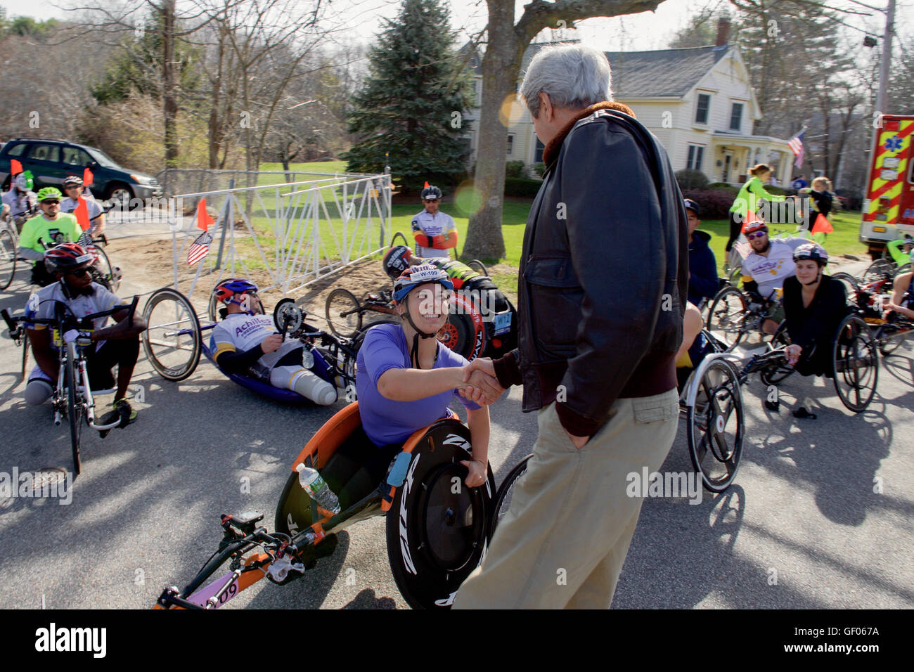 Sekretärin Kerry schüttelt die Hände mit den Wettbewerbern, bevor sie die Push-Rim Rollstuhl Division des Boston Marathons startete, ein legendäres Ereignis in Hopkinton, Massachusetts, bei dem inklusiver Sport und die Entschlossenheit der Athleten hervorgehoben werden. Stockfoto