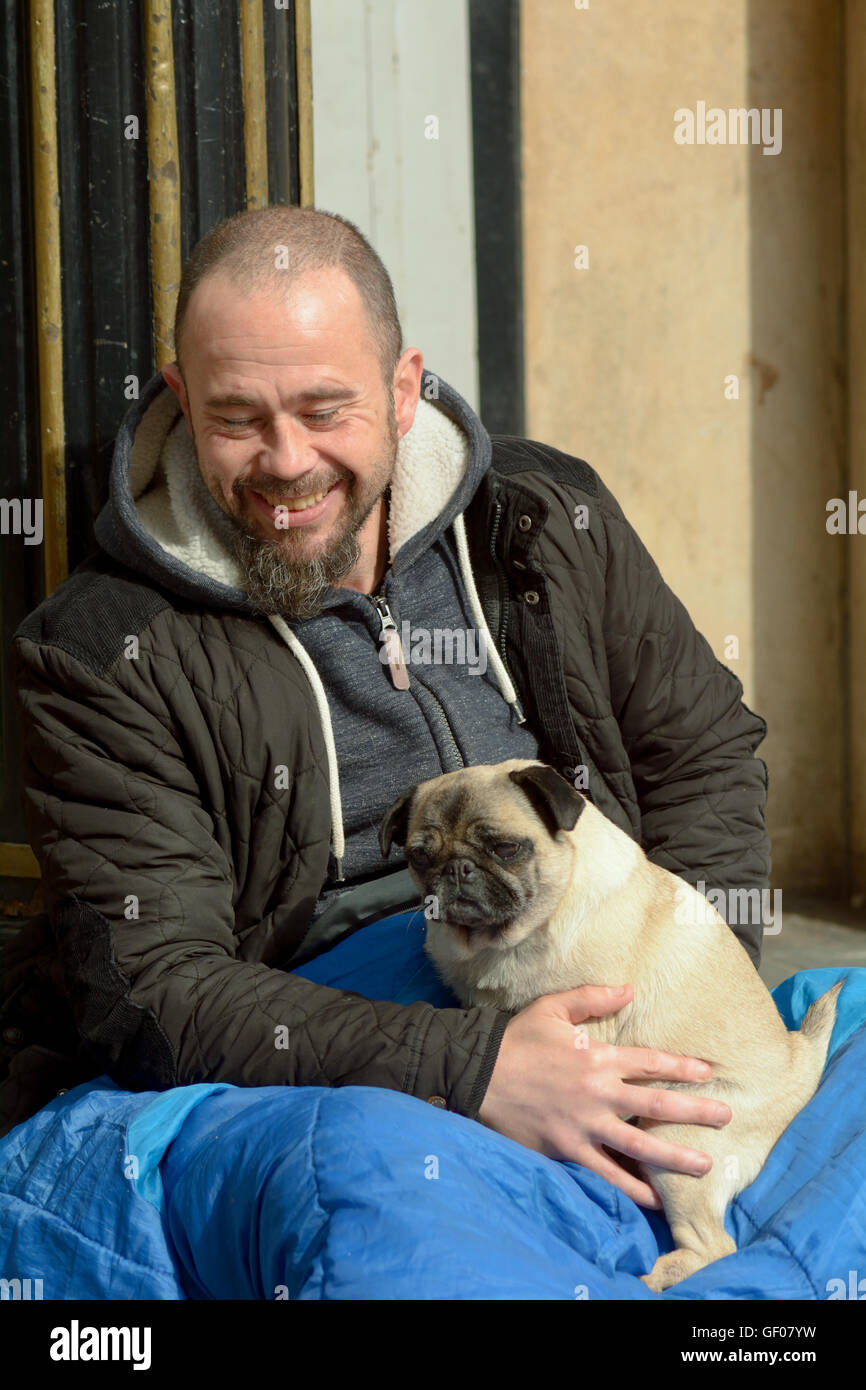 Obdachloser Porträt mit seinem Haustier Mops Hund in Cambridge, England Stockfoto