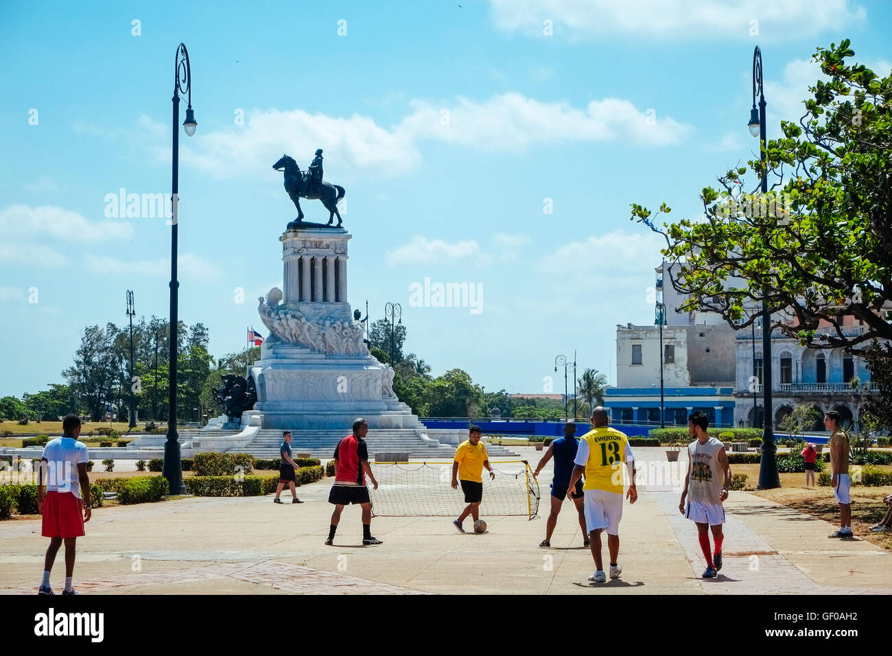 Eine Gruppe von Männern spielen Straßenfußball in der Nähe der Statue von General Maximo Gómez in Havanna, Kuba. Stockfoto