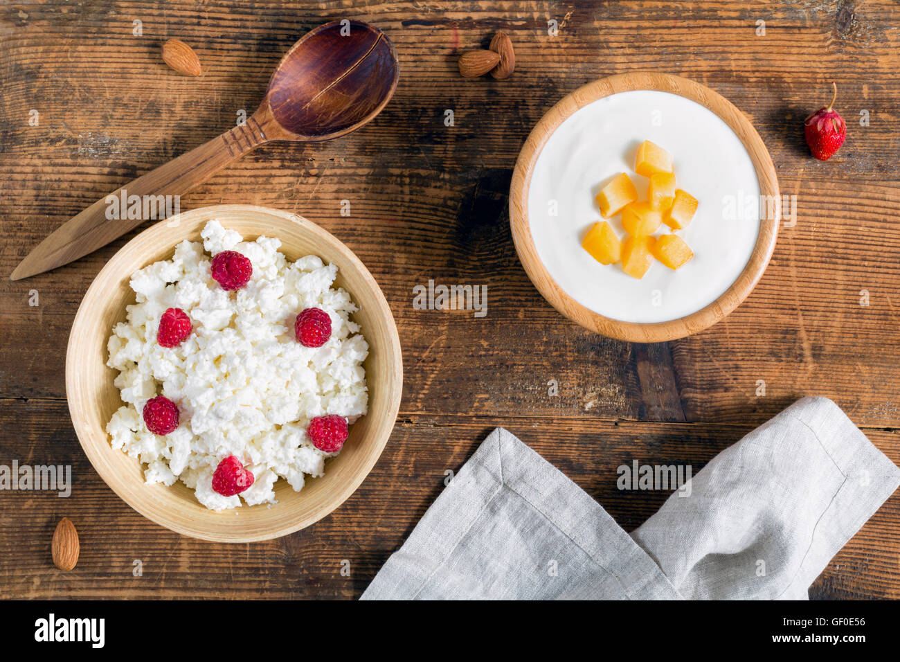 Milchprodukte: Joghurt und Quark mit Himbeeren und Obst auf hölzernen Hintergrund. Ansicht von oben Stockfoto