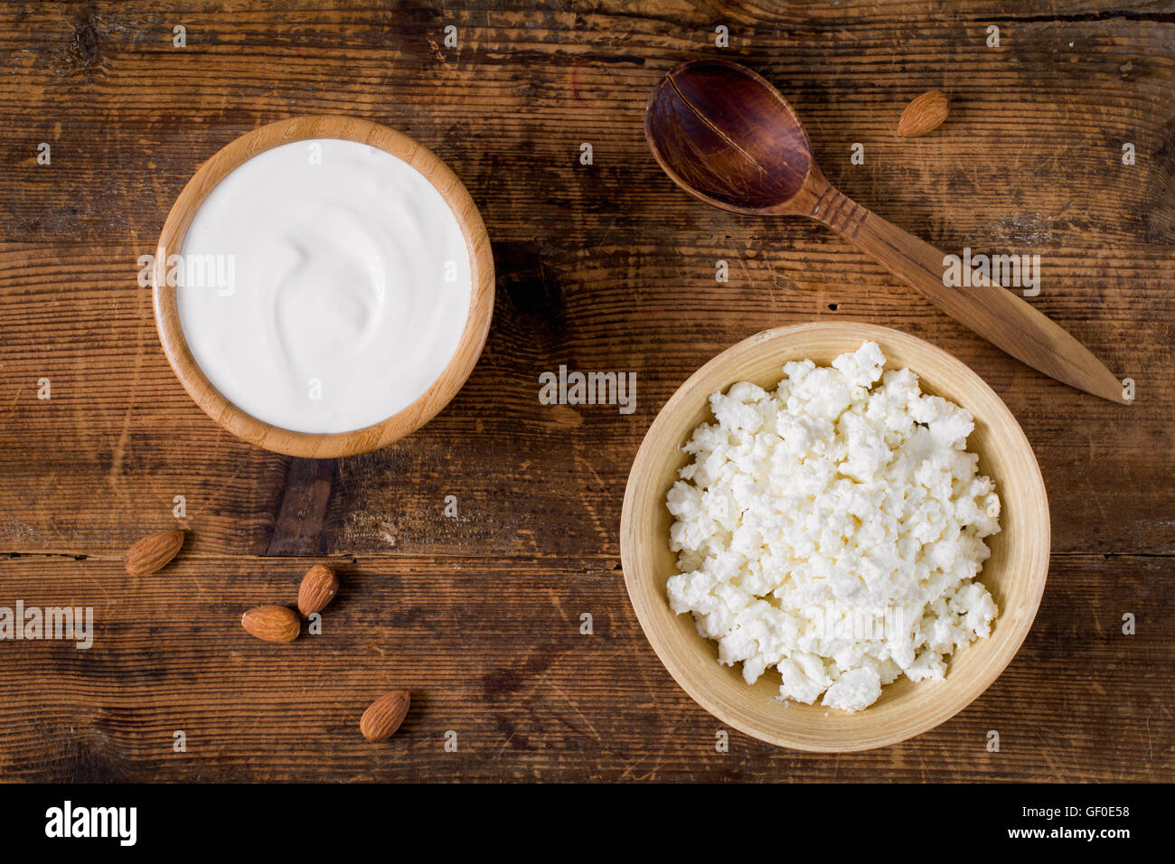 Joghurt und Quark in Schalen auf hölzernen Hintergrund, Top anzeigen Essen Stockfoto