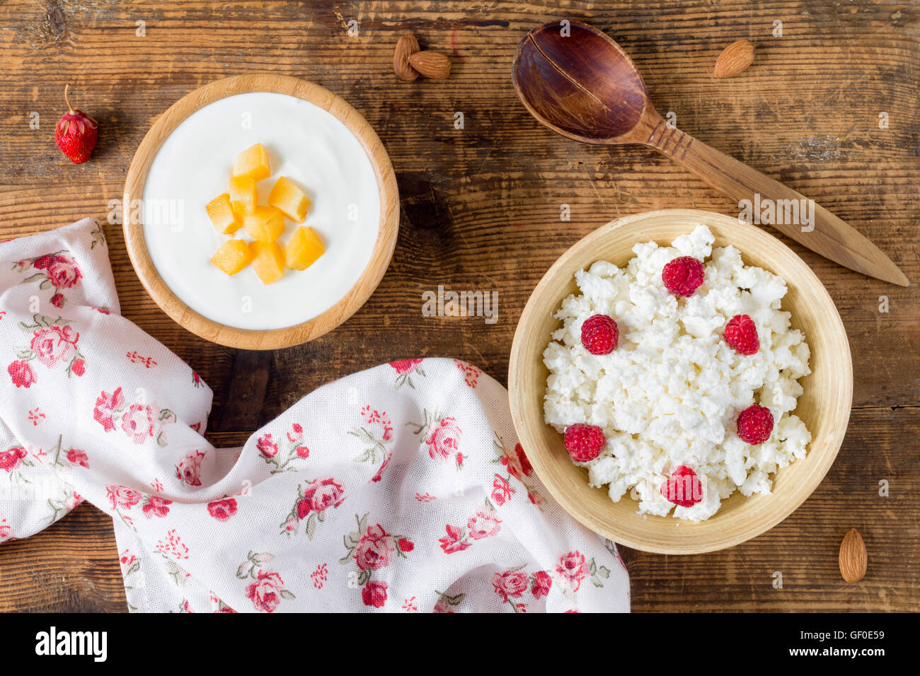 Frischer Quark und Joghurt in eine Schüssel mit Obst und Himbeere auf hölzernen Hintergrund. Draufsicht. Molkerei-Produkte Stockfoto