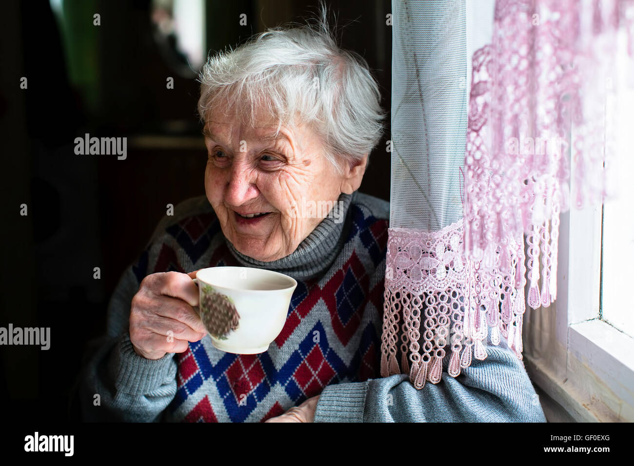 Glücklich Seniorin Porträt sitzen am Tisch und trinken Tee. Stockfoto