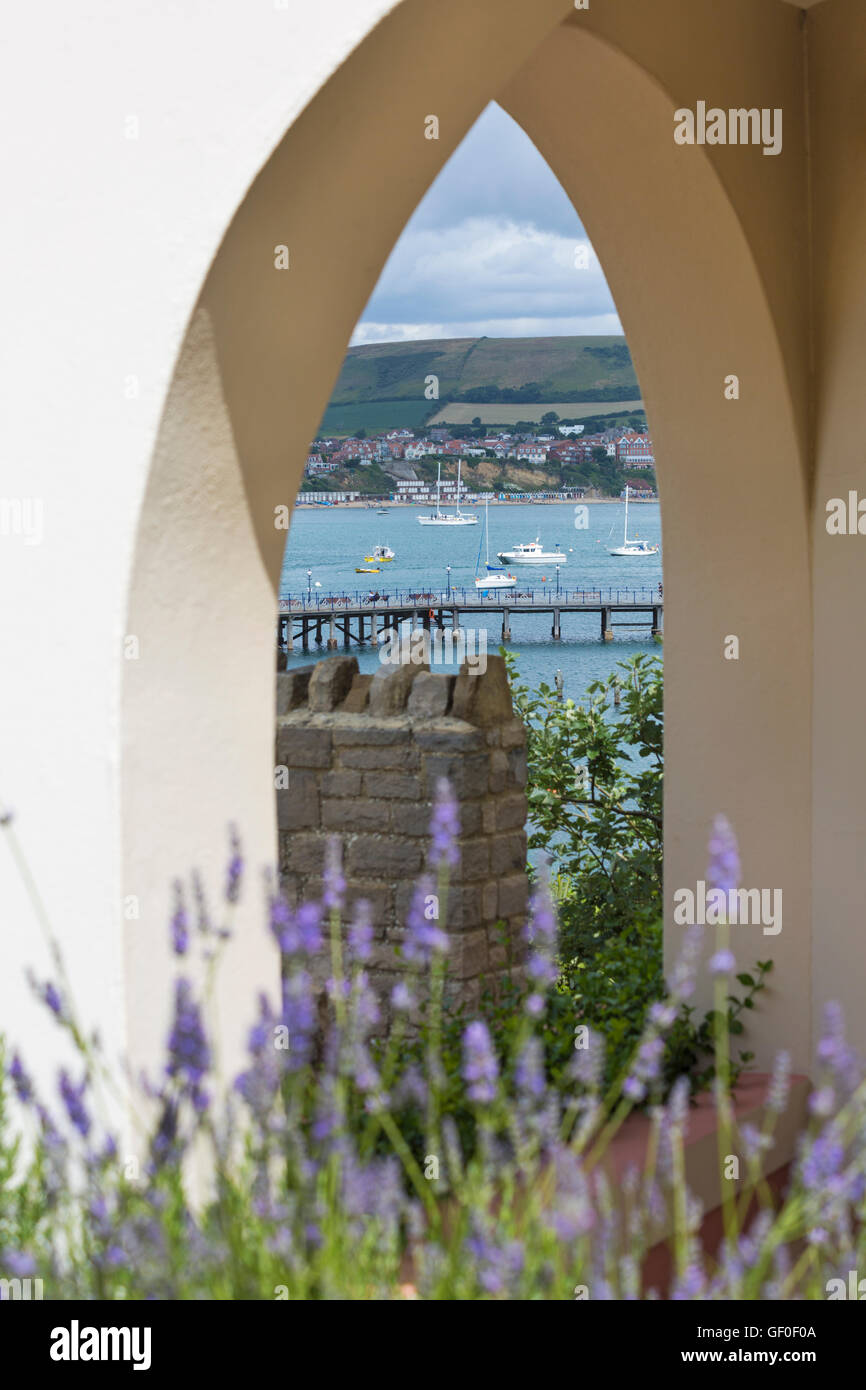 Auf der Suche durch Torbogen Swanage Pier mit Boote ankern in der Bucht und Dorset Küste im Juli Stockfoto