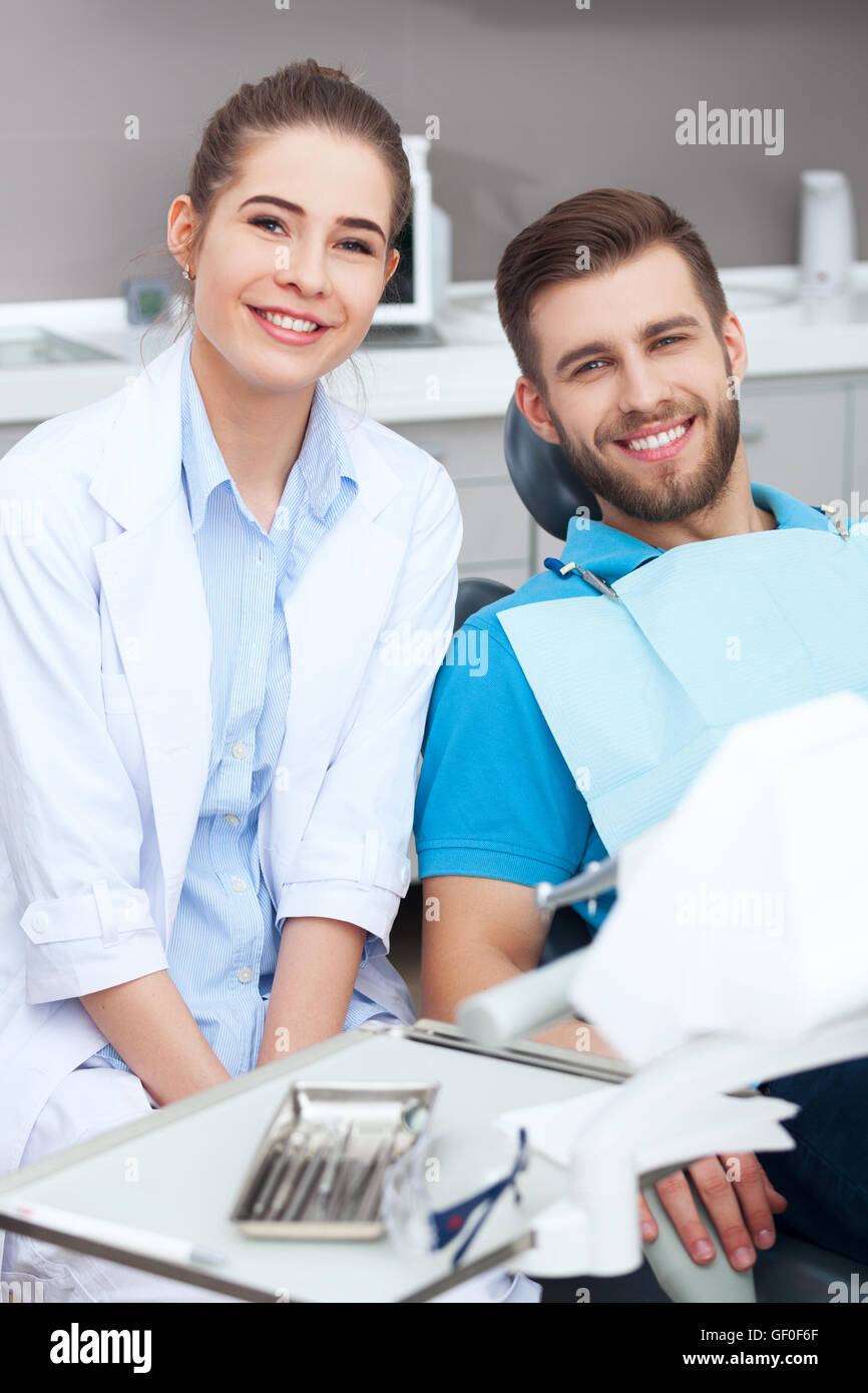 Mein Zahnarzt ist der beste! Portrait einer Zahnärztin und junger Mann in eine Zahnarztpraxis. Stockfoto