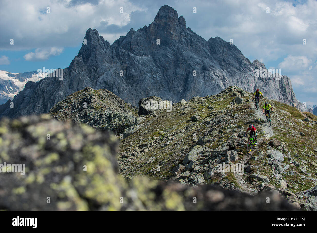 Drei Mountainbiker fahren den Grat zwischen Courchevel und Méribel Weg von der Aiguille du Fruit-Gipfel in den französischen Alpen Stockfoto