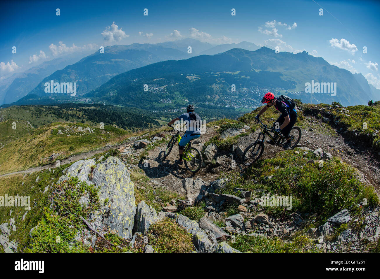 Zwei Mountainbiker fahren eine Strecke hoch über den französischen alpinen Ferienort Méribel. Stockfoto