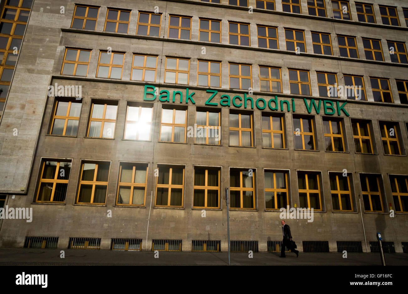 Ein Geschäftsmann Wanderungen vorbei an einer Bank im Zentrum von Wroclaw, Polen Stockfoto
