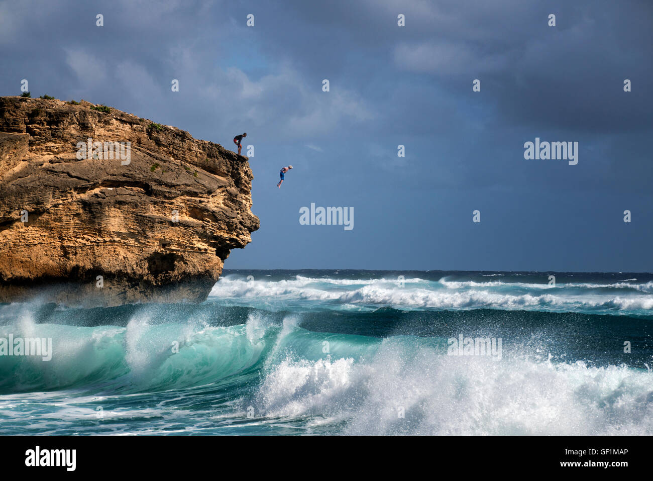Mann Jumpimg ins Wasser aus Fels am Shipwreck Beach. Poipu, Kauai, Hawaii Stockfoto