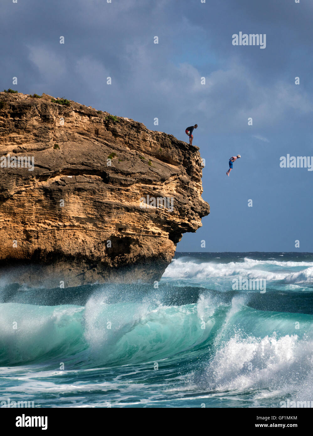Mann Jumpimg ins Wasser aus Fels am Shipwreck Beach. Poipu, Kauai, Hawaii Stockfoto