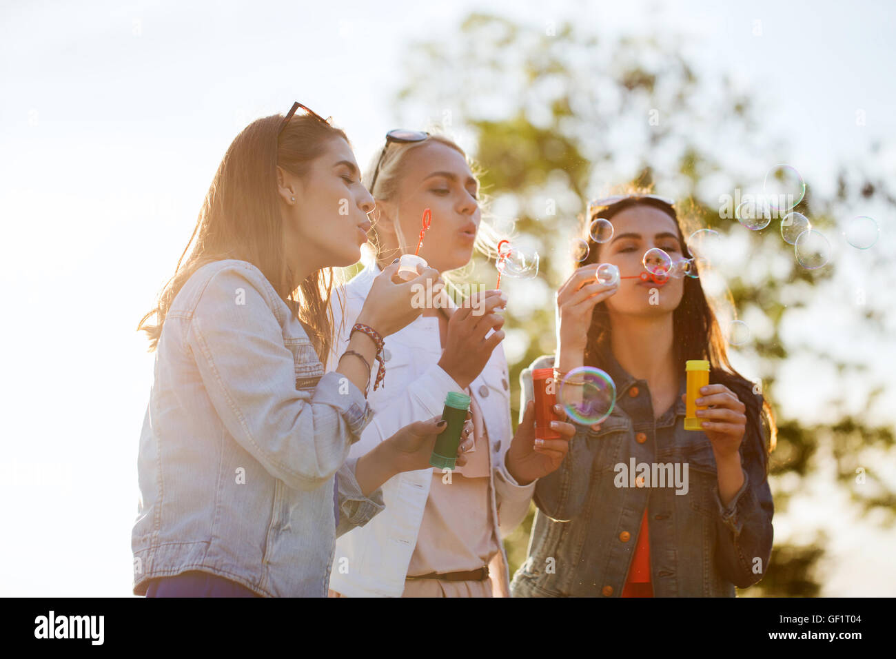 junge Frauen oder Mädchen bläst Seifenblasen im freien Stockfoto