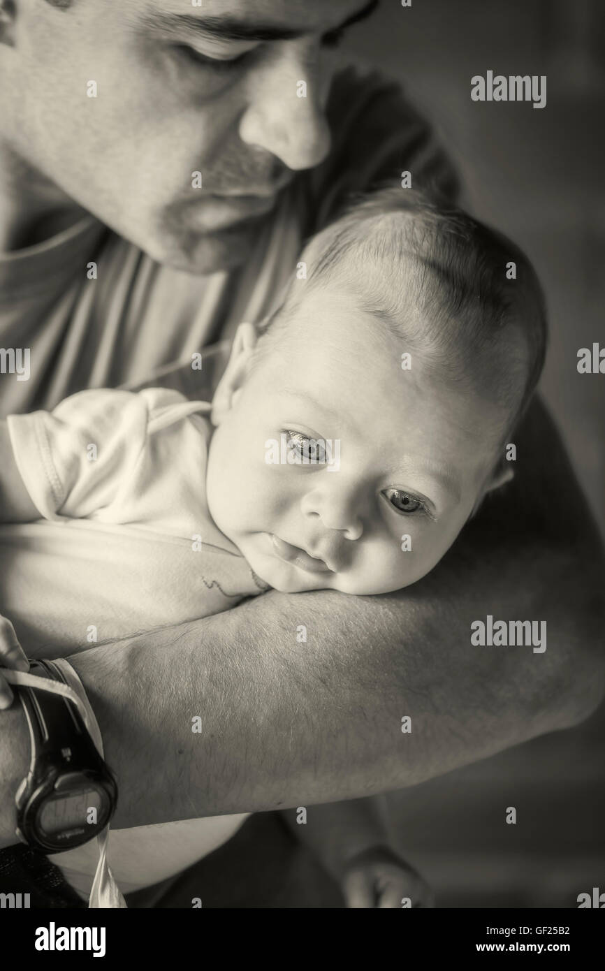 Latin American Vater Holding Newborn Baby Boy In seine Arme, Monochrome schießen Stockfoto