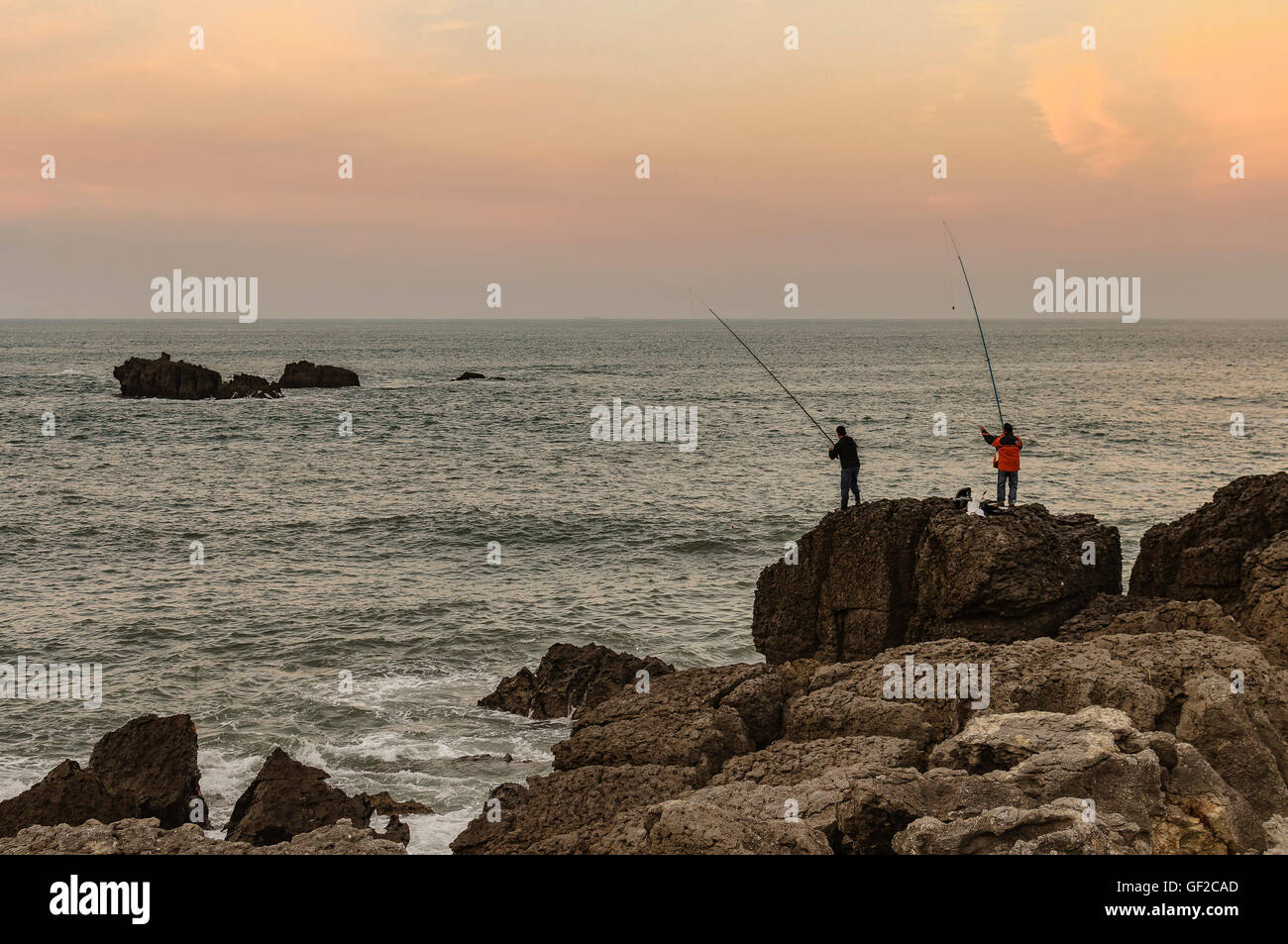 Zwei Männer Angeln auf einem großen Felsen auf der Nordküste von Spanien, Noja, Kantabrien, Europa Stockfoto