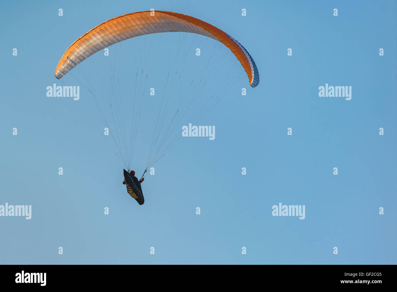 Gleitschirm im Flug mit bunten Flügel, Baldachin gegen blauen Himmel. Ansichten aus der Sicht der Pena Cabarga, Kantabrien, Spanien. Stockfoto