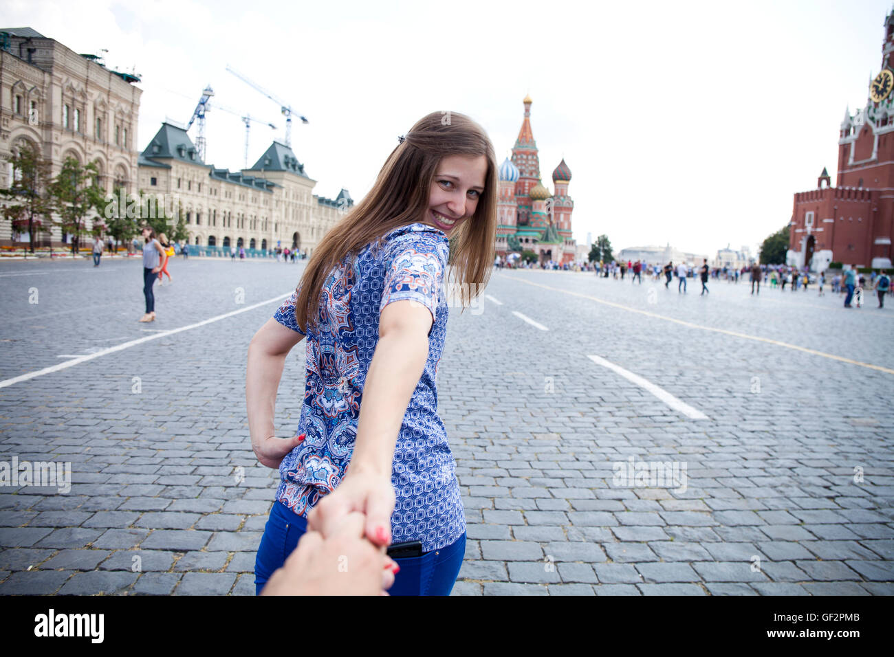 Folge mir. Glückliches Mädchen zieht die Jungs Hand auf dem Roten Platz in Moskau, Russland Stockfoto