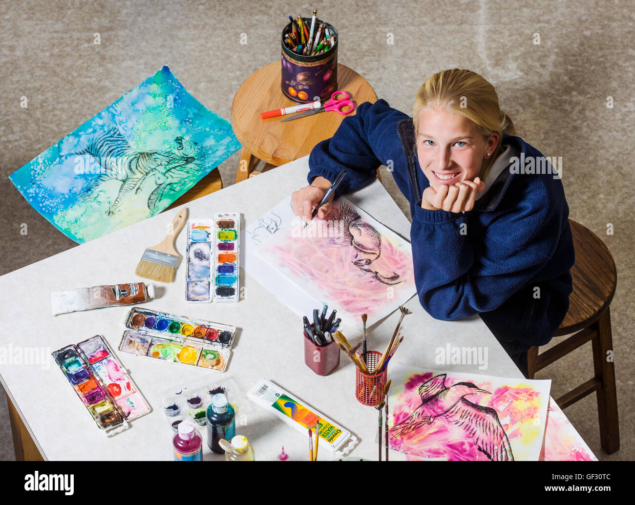 Lächelnde blonde behaarte weibliche High-School-Schüler im Kunstunterricht. Stockfoto