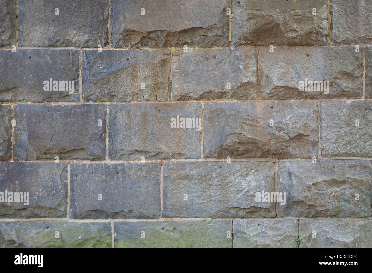 Braun schneiden Steinmauer mit Grünalgen Stockfoto