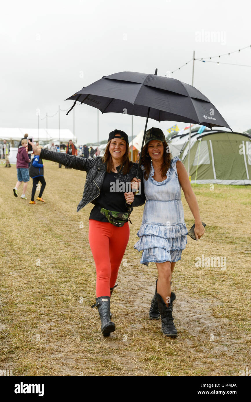 Carfest Nord, Bolesworth, Cheshire, UK. 29. Juli 2016. Zwei Mädchen, die ihren Weg auf einem der Campingplätze im Regen. Die Veranstaltung ist die Idee von Chris Evans und Funktionen 3 Tage von Autos, Musik und Unterhaltung mit einem Gewinn an die Stiftung Kinder in Not gespendet. Bildnachweis: Andrew Paterson/Alamy Live-Nachrichten Stockfoto