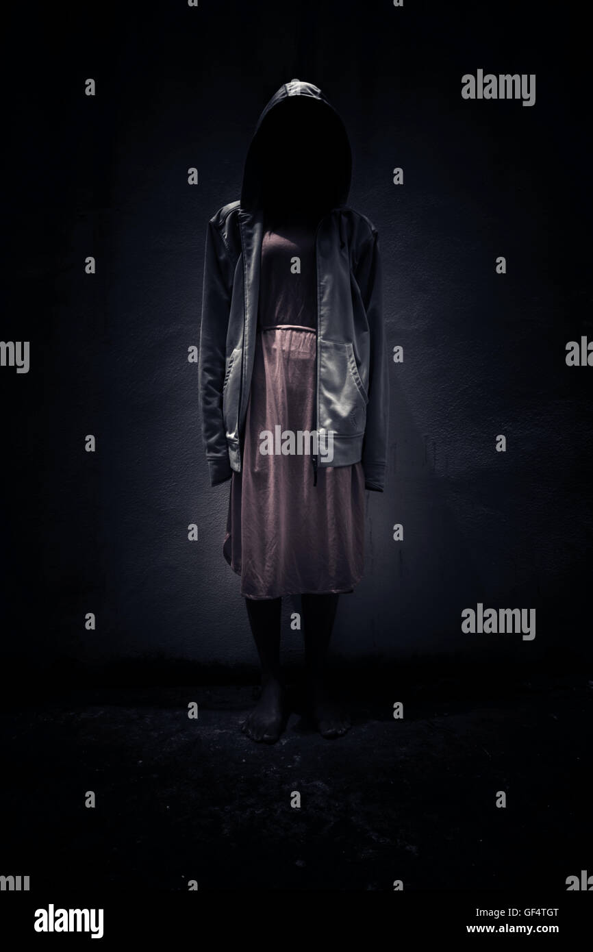 Frau trägt Hoodie versteckt im Hintergrund dunkel, beängstigend für Bucheinband Stockfoto