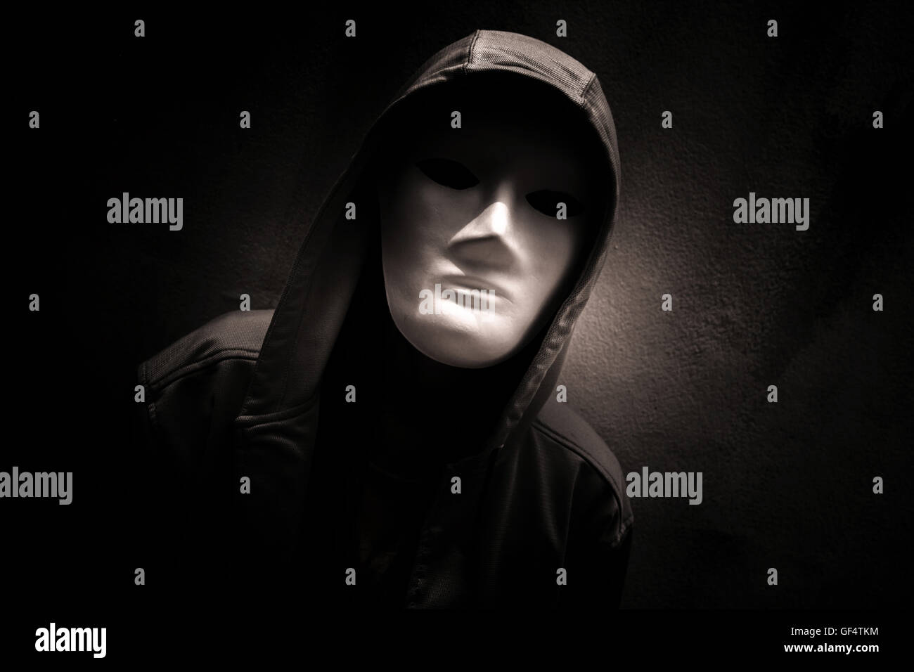 Dunkle Lehre, geheimnisvolle Frau trägt weiße Maske unter Hoodie, beängstigend Hintergrund für Bucheinband Stockfoto