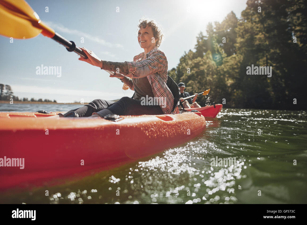 Schuss von senior Frau Kanu im See an einem Sommertag. Reife Frau eine Kajak in See paddeln. Stockfoto