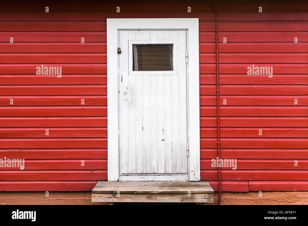 Kleine weiße geschlossene Tür in rot ländlichen Holzwand, Foto Hintergrundtextur. Skandinavischen Stil Stockfoto