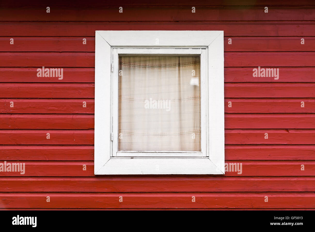 Roten Holzwand mit kleinen Fenster in weißer Rahmen, typisch skandinavisch Leben Haus Architektur Fragment Stockfoto