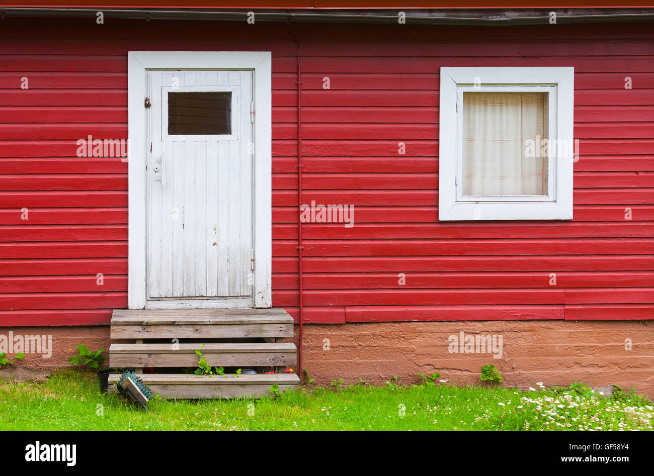 Kleine weiße Tür und Fenster in roten ländlichen Holzwand, Foto Hintergrundtextur geschlossen. Skandinavischen Stil Stockfoto