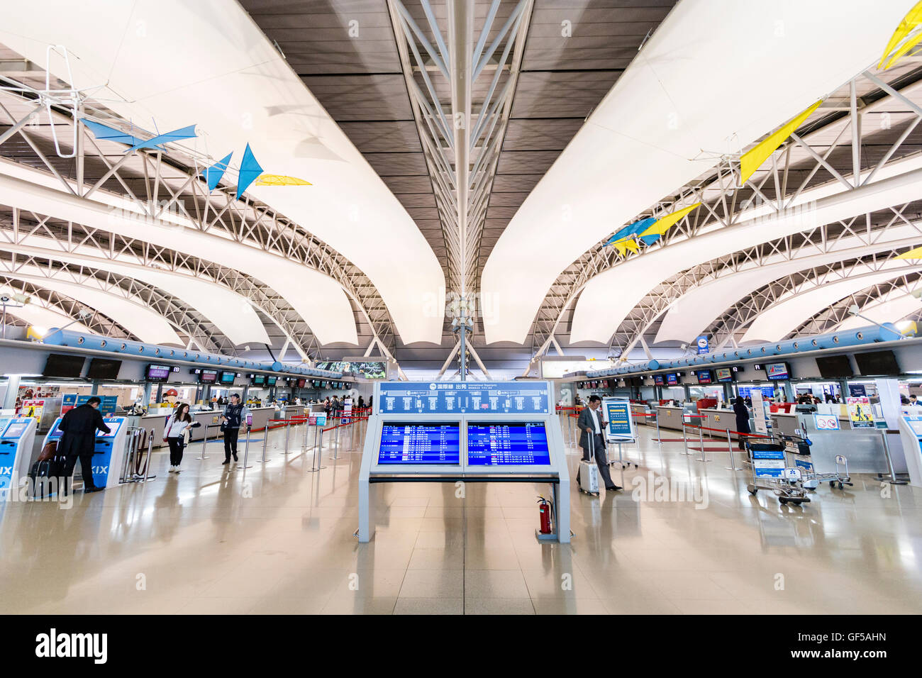 Japan, Kansai Airport, KIX. Interieur von Terminal 1. International check-in. Informationen zeigt in der Mitte, Check in-Schalter auf beiden Seiten. Stockfoto