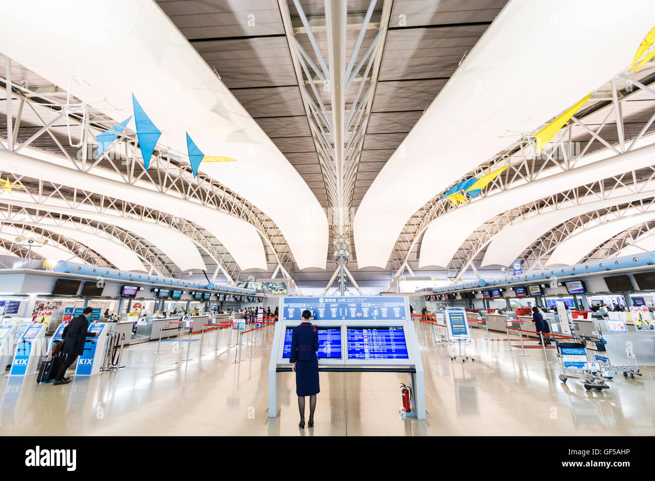 Japan, Kansai Airport, KIX. Interieur von Terminal 1. International check-in. Informationen zeigt in der Mitte, Check in-Schalter auf beiden Seiten. Stockfoto