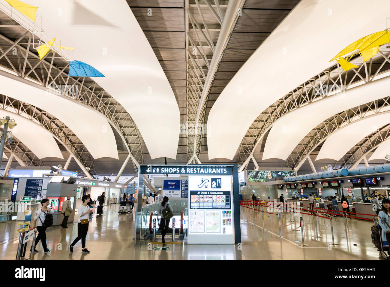 Japan, Kansai Airport, KIX. Interieur von Terminal 1. International check-in. Informationen zeigt in der Mitte, Check in-Schalter auf beiden Seiten. Stockfoto