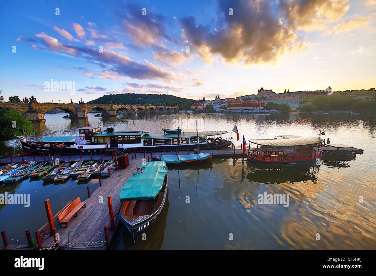 Karlsbrücke über die Moldau, Prager Burg, St Vitus Cathedral und Boote bei Sonnenuntergang in Prag, Tschechische Republik Stockfoto