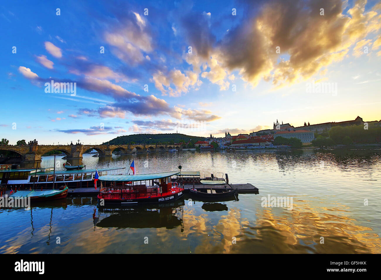 Karlsbrücke über die Moldau, Prager Burg, St Vitus Cathedral und Boote bei Sonnenuntergang in Prag, Tschechische Republik Stockfoto