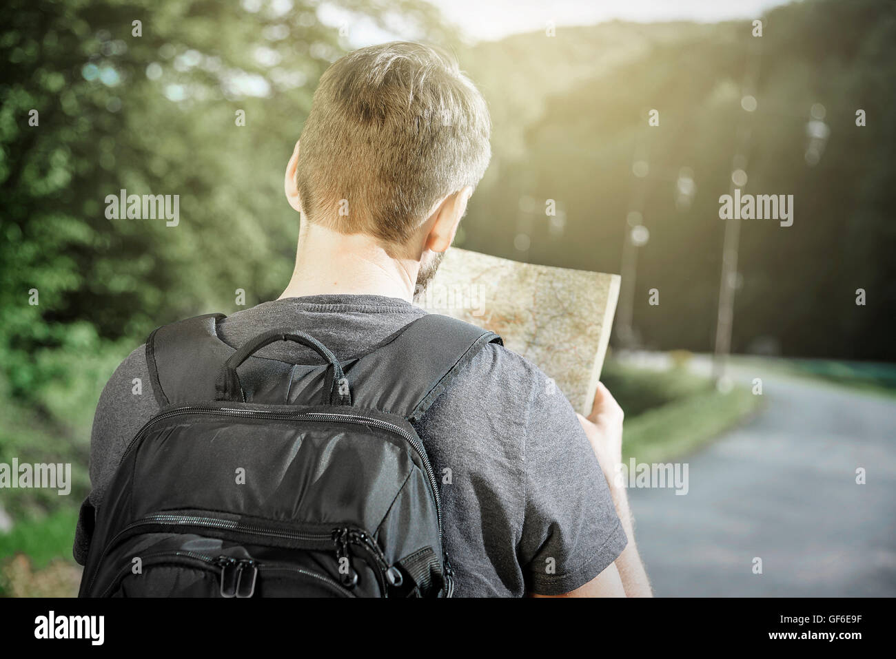 Reisender Mann Suche richtige Richtung auf Karte, Freiheit und aktiven Lifestyle-Konzept Stockfoto