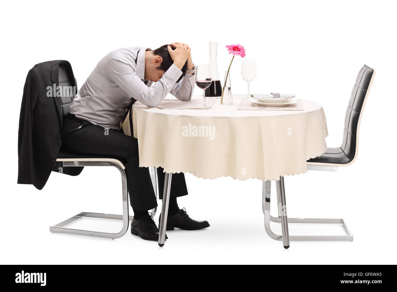 Verzweifelten Kerl sitzt allein an einem Tisch im Restaurant mit dem Kopf nach unten isoliert auf weißem Hintergrund Stockfoto