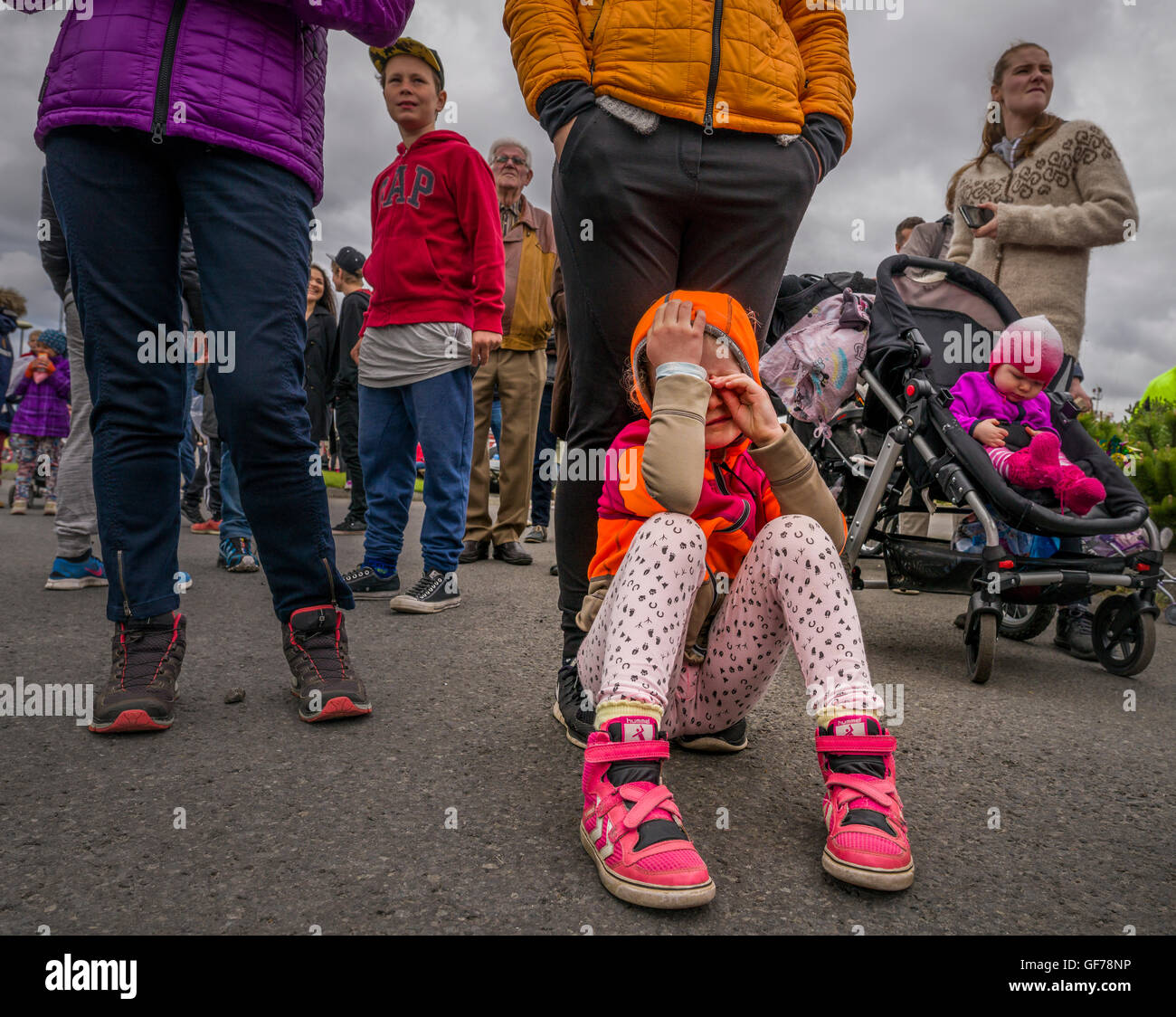 Junges Mädchen weinend auf dem Boden auf der jährlichen Seemann Festival, Hafnarfjordur, Island Stockfoto