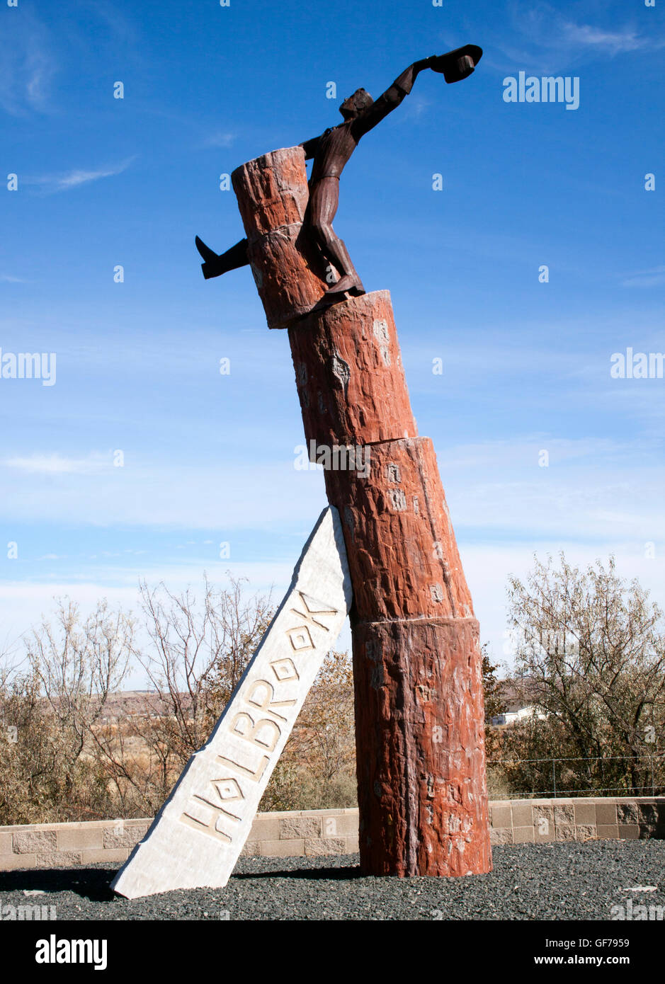 „Welcome to Holbrook“-Schild in Arizona mit einem Cowboy, der auf versteinerten Baumstämmen reitet, eine skurrile Attraktion am Straßenrand der Route 66. Stockfoto