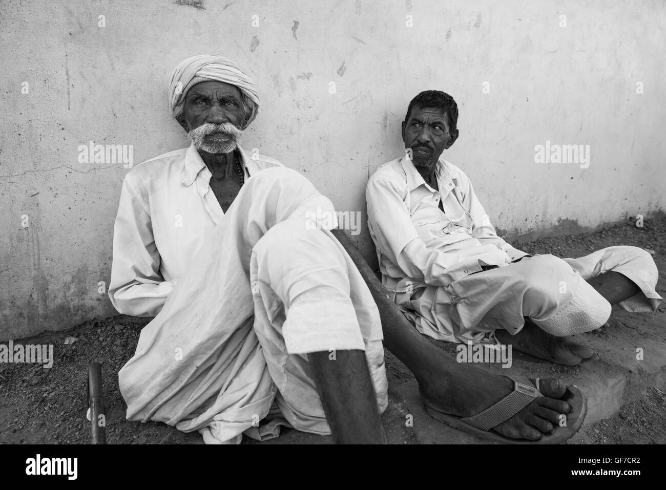 Ältere Rabari Männer kühlen im Schatten in der Nachmittagshitze. Bhujodi Dorf, Bhuj Gebiet, Kutch, Gujarat, Indien Stockfoto