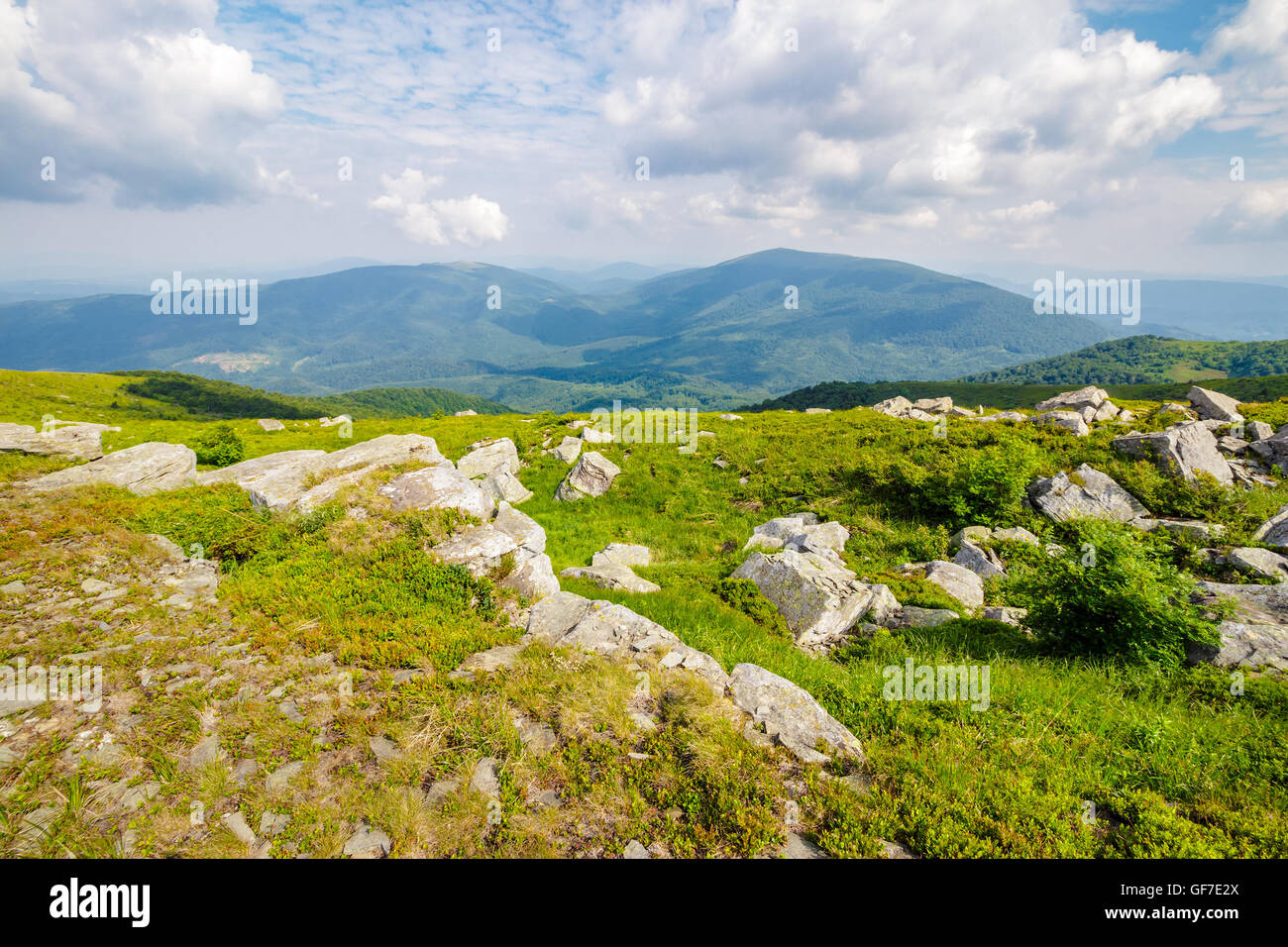 Berg-Sommer-Landschaft. Wiese mit großen Steinen unter dem Rasen über die Hügel in der Nähe der Spitze des Gebirges Stockfoto