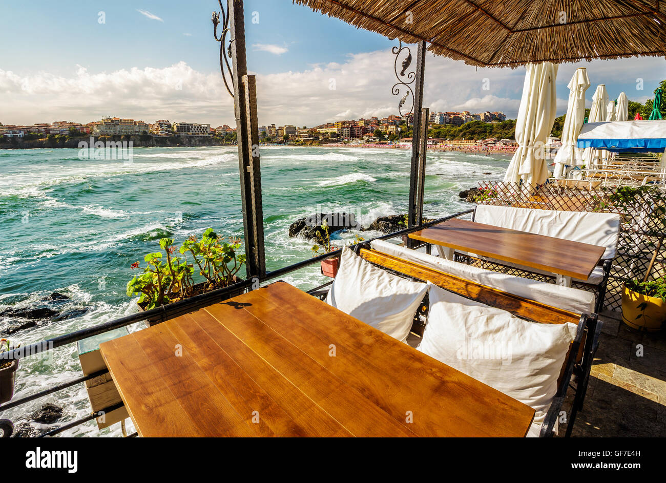 Restauranttisch mit Bank und Kissen an der Meeresküste in Altstadt Stockfoto