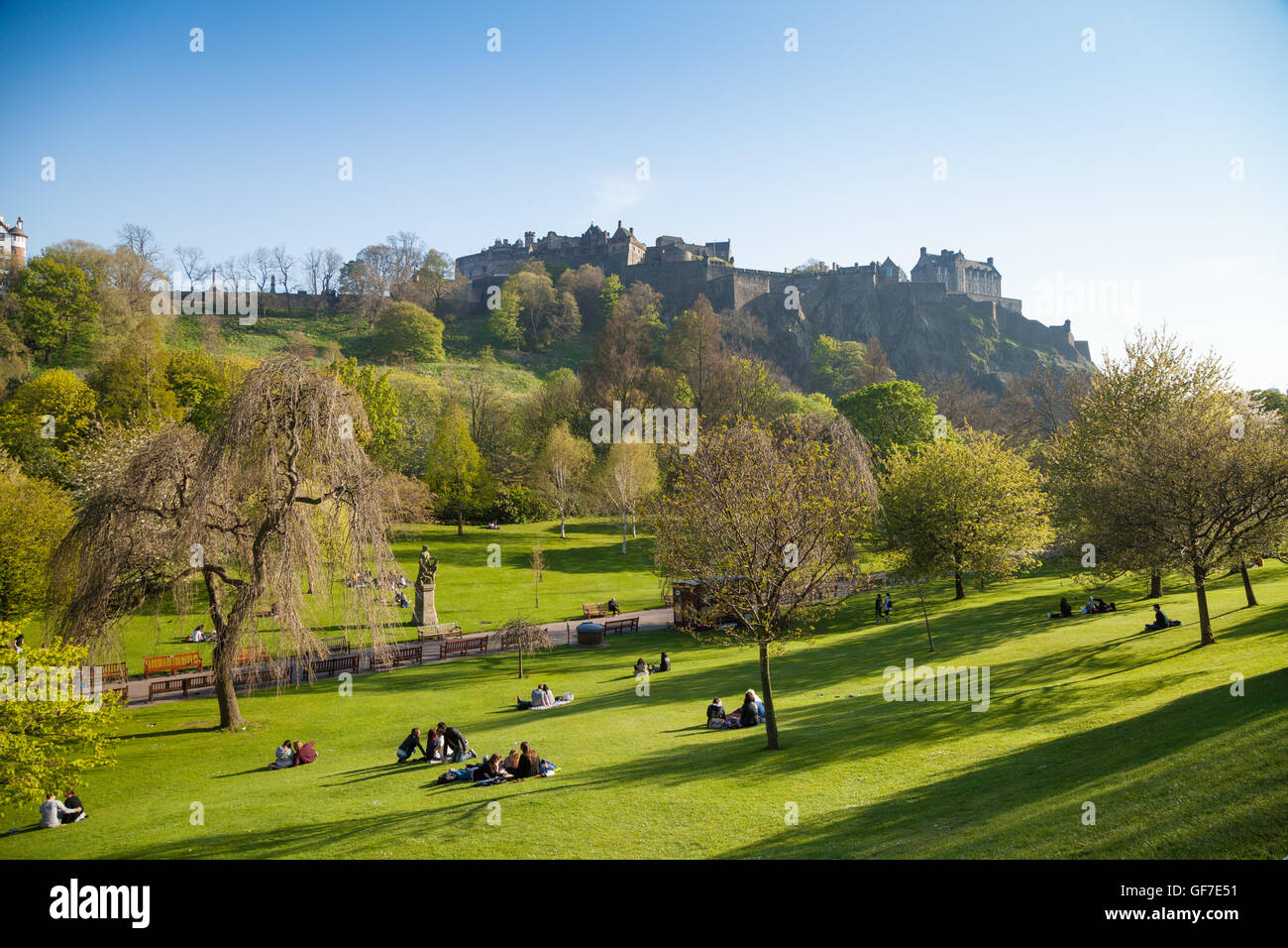 Die Menschen genießen die Sonne in den Princess Street Gardens, Edinburgh Castle im Hintergrund. Stockfoto