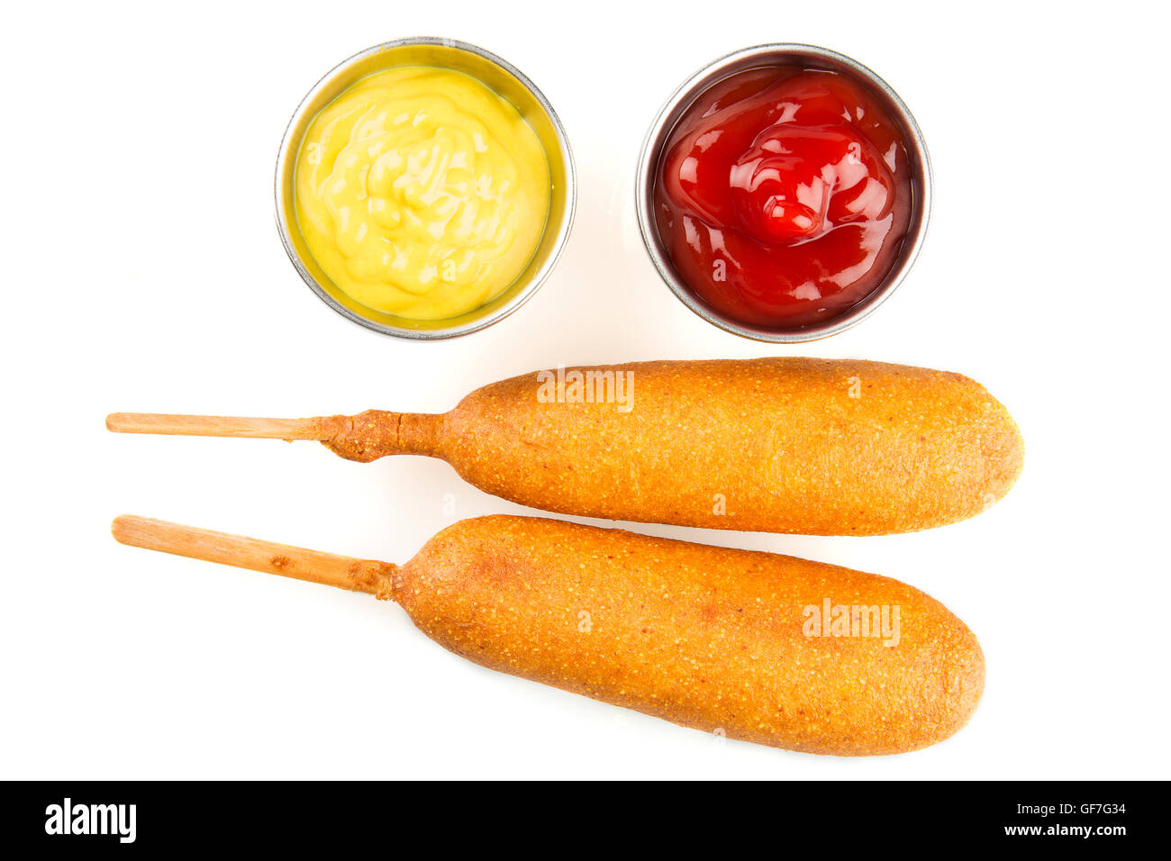 Zwei Corndogs mit Senf und Ketchup auf der Seite.  Isoliert auf weißem Hintergrund. Stockfoto