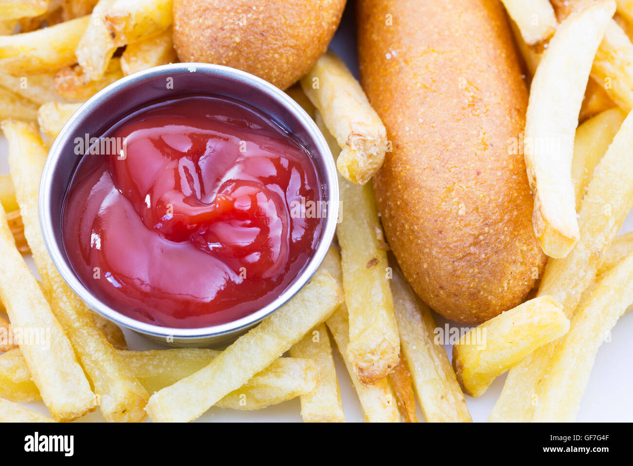 Nahaufnahme von Ketchup mit Pommes Frites und Corndogs Stockfoto